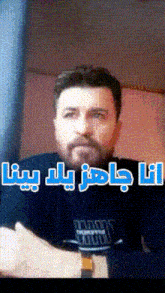 a man with a beard is wearing a black shirt that says ' i love you ' on it