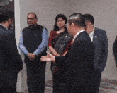 a man in a suit talks to a woman in a sari