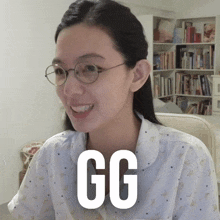 a woman wearing glasses and a shirt that says gg is smiling