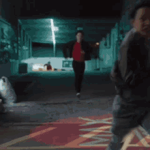 a man in a red shirt is running down a dark alleyway .