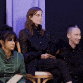 a woman in a green jacket sits next to a man