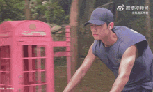 a man wearing a baseball cap and a blue tank top is riding a bike .