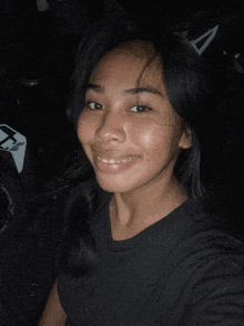 a woman in a black shirt is smiling in front of a motorcycle with a fox logo on it