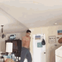 a shirtless man is dancing in a living room without a shirt .