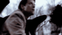 a man is flying through the air in a blurry photo while holding a black object .