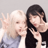 two girls are posing for a picture and one is wearing a t-shirt that says stray