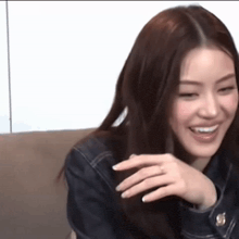 a woman is sitting on a couch laughing and smiling .