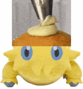 a yellow stuffed animal with blue eyes is being decorated