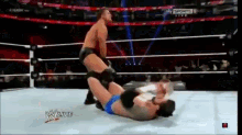 two men are wrestling in a wrestling ring and the words w live are on the screen