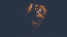 a dark sky with a few clouds and a light coming out of it