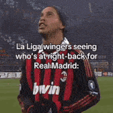 a soccer player wearing a red and black jersey with the word bwin on it