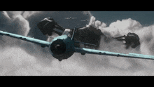 a plane is flying through a cloudy sky with another plane behind it