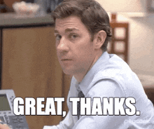 a man in a blue shirt and tie is sitting at a desk and says `` great thanks '' .