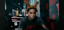 a man with a bunny ear headband is blowing smoke out of his mouth .