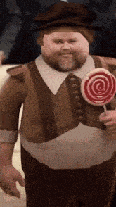 a man with a beard is holding a lollipop .