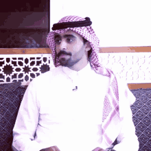 a man wearing a head scarf and a white shirt