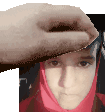 a hand is holding a piece of paper over a person 's head .