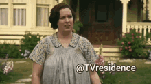 a woman standing in front of a house with the words @tvresidence written on the bottom