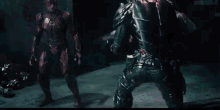 a man in a black suit is fighting another man in a black suit in a dark room .