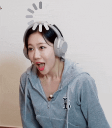 a woman wearing headphones and a hoodie with the letter b on the front