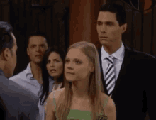 a man in a suit and tie is talking to a woman in a green dress