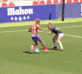 a soccer game is being played in front of an ad for baxi