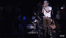 a man singing into a microphone in front of a drum set that says hd on it