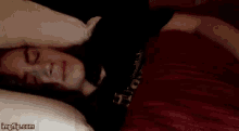 a close up of a person 's face with a red blanket .