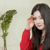 a woman in a red sweater wipes her face with her hand