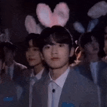 a group of young men wearing bunny ears are standing in a room .