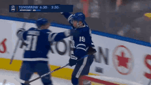a hockey player with the number 19 on his jersey is hugging another player