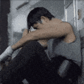 a man sitting on the floor with his head down and his hands wrapped in bandages