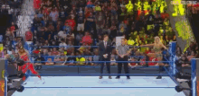 a man in a suit and tie is standing in a wrestling ring .