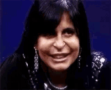 a woman wearing a necklace and earrings is making a funny face .