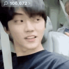 a young man is sitting in a car with his mouth open and looking at the camera .