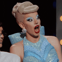 a woman with a surprised look on her face is wearing a blue dress