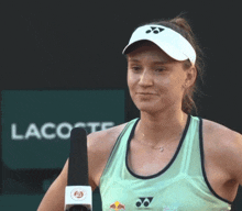 a woman holds a microphone in front of a lacoste sign