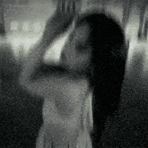 a blurry black and white photo of a woman dancing in a room .