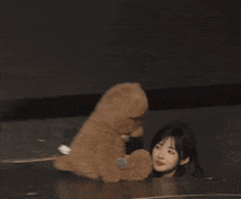 a woman is looking at a teddy bear with a microphone on it