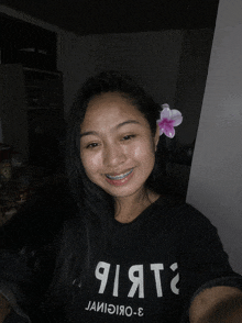 a girl with a flower in her hair is wearing a black shirt that says ' яіята '