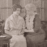 two women are sitting next to each other and talking