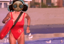 a woman in a red swimsuit is carrying a life preserver on the beach