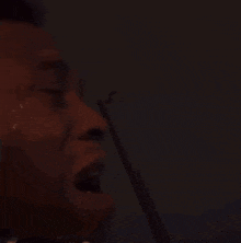 a close up of a man 's face with tears coming out of his eyes and mouth .