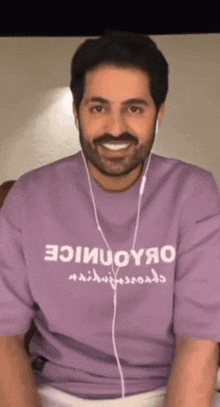 a man with a beard wearing a purple shirt that says oiiuoyjao