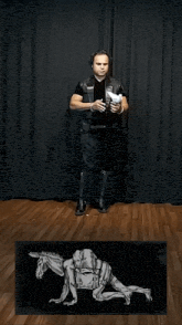 a man in a black vest holds two white birds in his hands