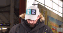 a man wearing a white hat that says benzin racing team on it