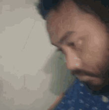 a close up of a man 's face with a beard looking down .