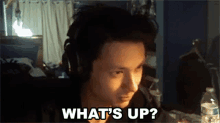 a man wearing headphones says what 's up in a dark room