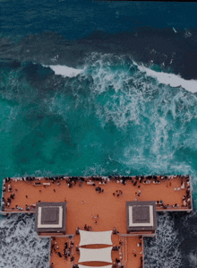 an aerial view of a cruise ship in the ocean with people on the deck