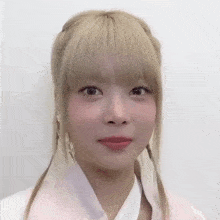 a girl with blonde hair and pigtails looks at the camera